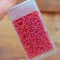 11/0 Light Cranberry Lined Topaz Luster